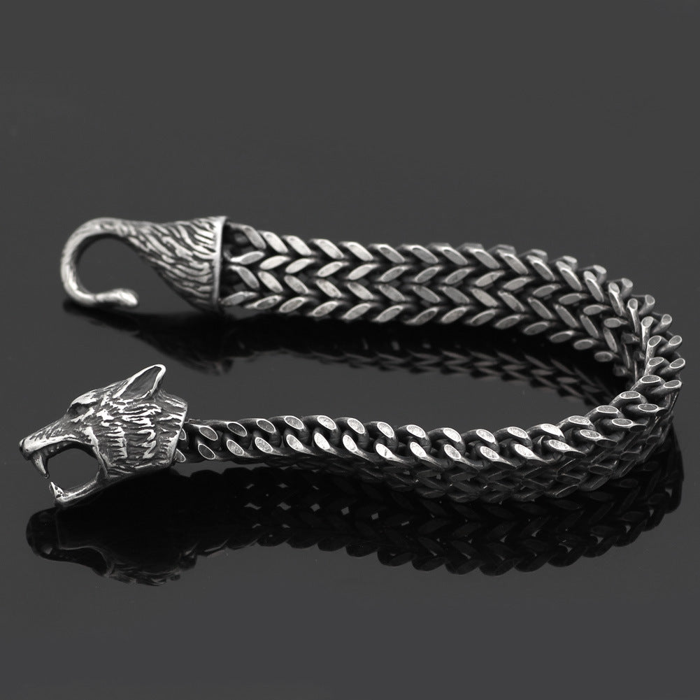 Men's jewelry bracelet with fierce wolf head and hook clasp, crafted in black stainless steel Cuban chain for a rugged vintage look.
